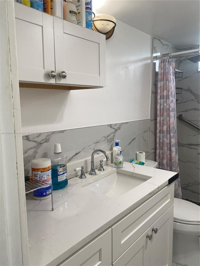 bathroom with vanity, curtained shower, tile walls, toilet, and marble finish floor