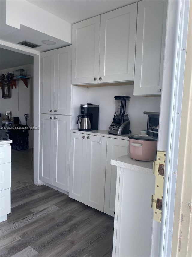 kitchen featuring visible vents, white cabinets, light countertops, and dark wood-type flooring