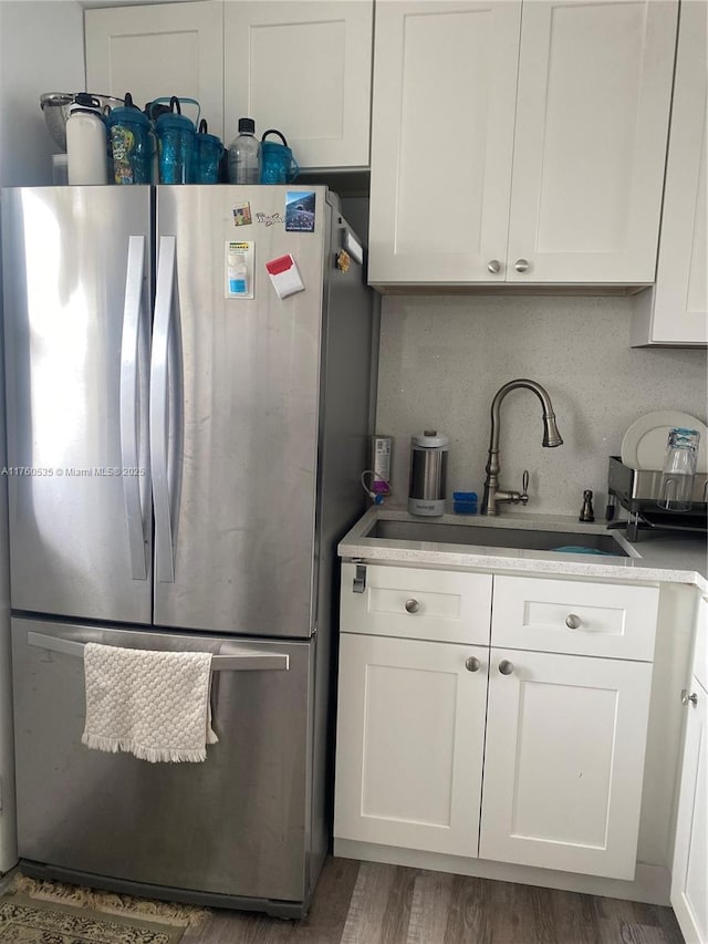 kitchen featuring a sink, white cabinetry, light countertops, and freestanding refrigerator