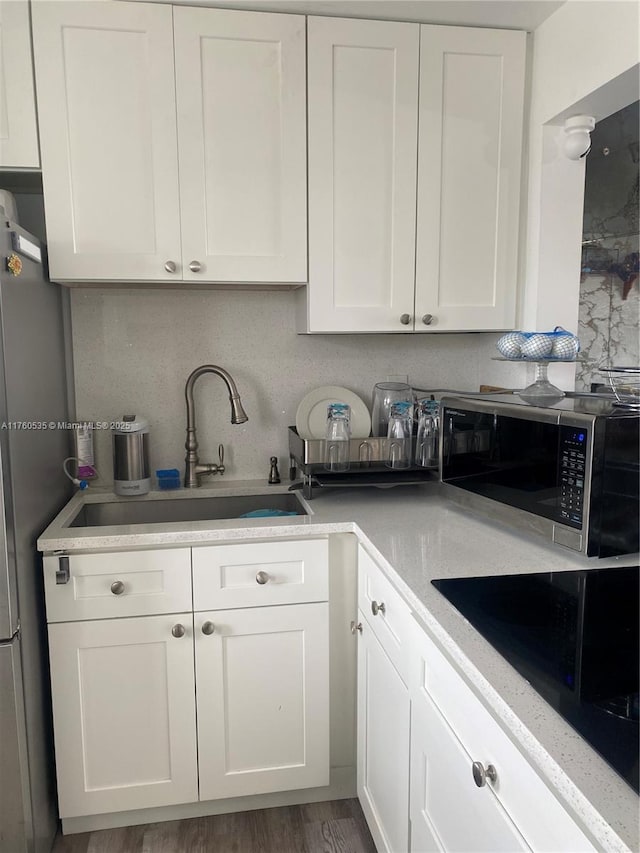 kitchen with a sink, appliances with stainless steel finishes, and white cabinets