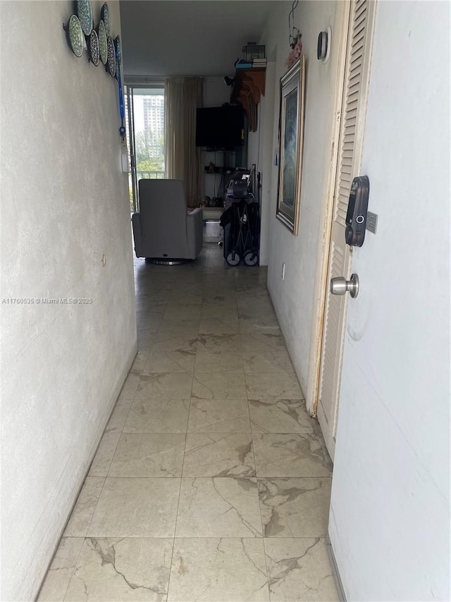 hallway featuring marble finish floor