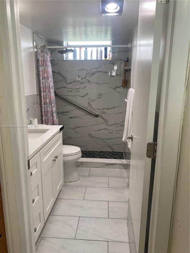 bathroom featuring a marble finish shower, toilet, marble finish floor, and vanity