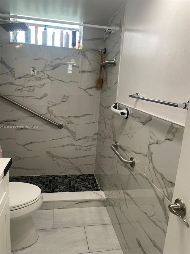 bathroom featuring vanity, toilet, marble finish floor, and a marble finish shower