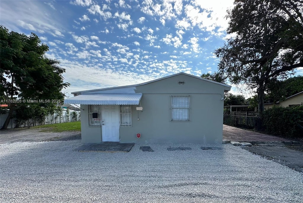 exterior space with an outbuilding, fence, and stucco siding