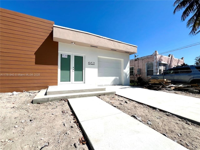 view of exterior entry with stucco siding and french doors