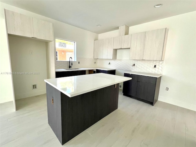 kitchen featuring a sink, a center island, decorative backsplash, and modern cabinets