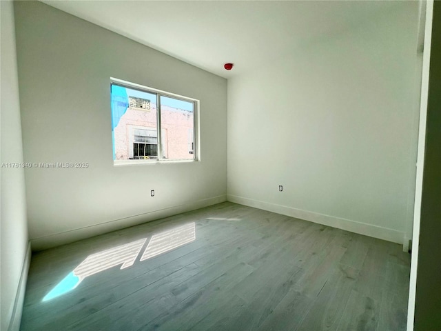 unfurnished room featuring baseboards and wood finished floors