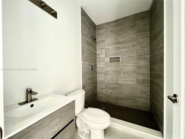 full bath featuring tile patterned flooring, a sink, a tile shower, and toilet