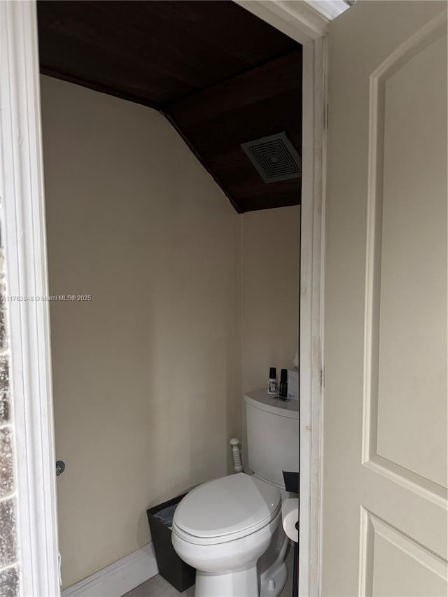 bathroom featuring lofted ceiling, toilet, and visible vents