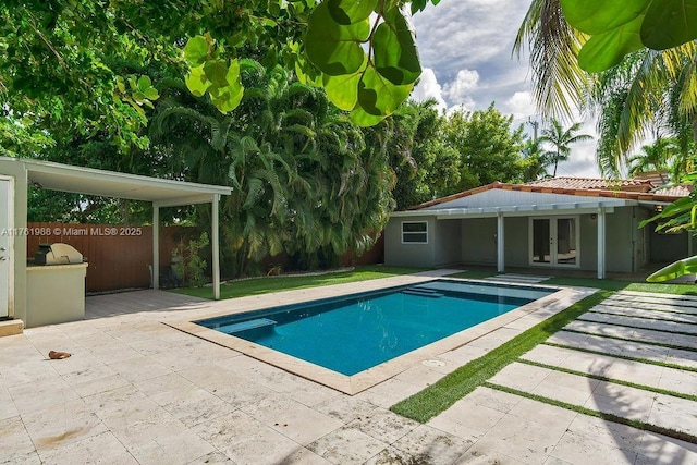 pool featuring french doors, fence, and a patio area