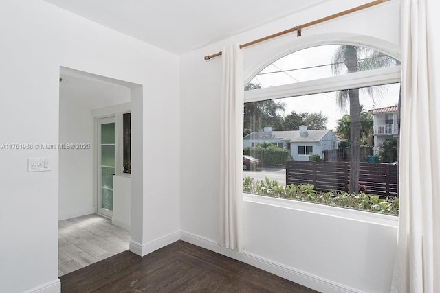 empty room featuring baseboards and wood finished floors