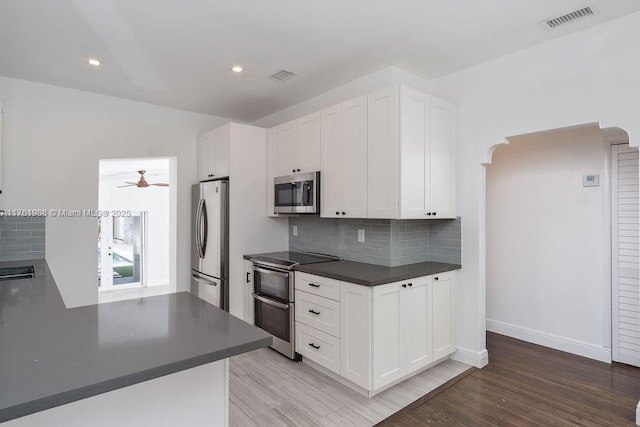 kitchen featuring white cabinetry, dark countertops, visible vents, and stainless steel appliances