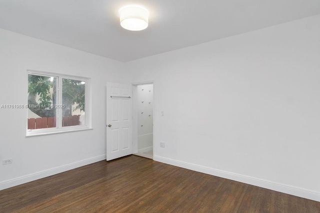 empty room with baseboards and wood finished floors