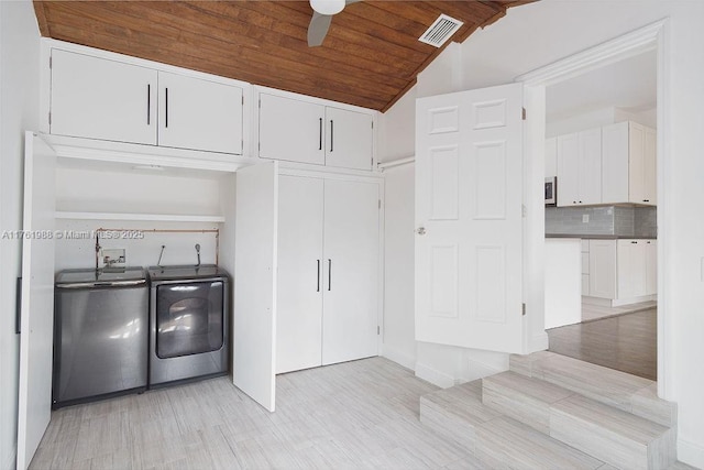 washroom featuring visible vents, a ceiling fan, cabinet space, separate washer and dryer, and wood ceiling