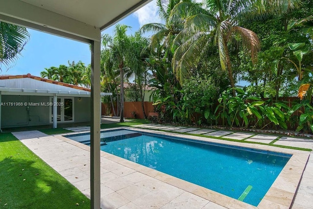 view of swimming pool featuring a fenced in pool, french doors, a patio, and fence