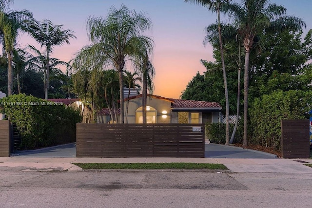 mediterranean / spanish house with a fenced front yard