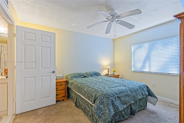 bedroom with a ceiling fan, light colored carpet, and a textured ceiling