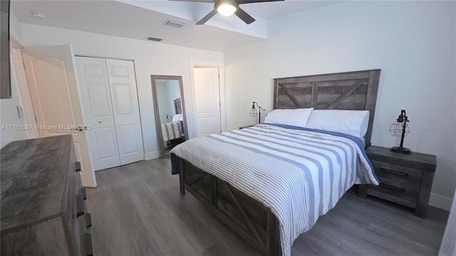 bedroom with wood finished floors, visible vents, a closet, and ceiling fan