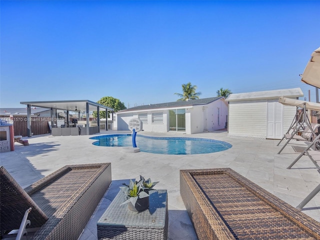 view of pool featuring an outbuilding, a fenced in pool, fence, a storage unit, and a patio area