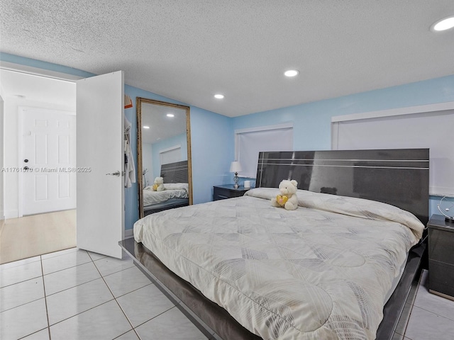 bedroom with recessed lighting, a closet, a textured ceiling, and light tile patterned flooring