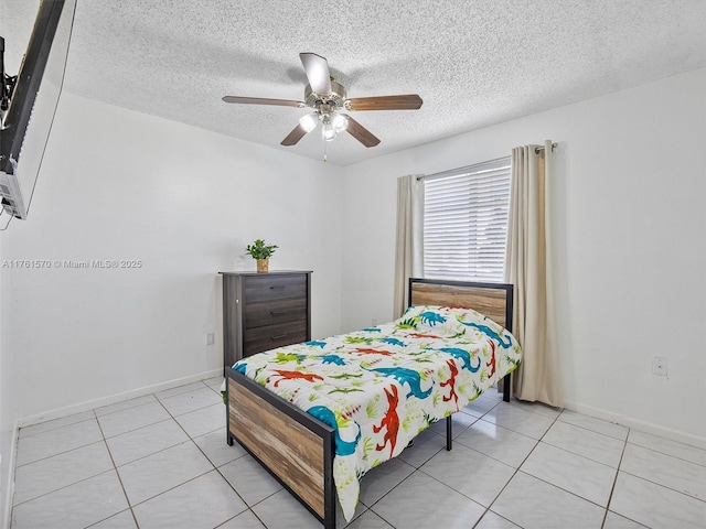 bedroom featuring light tile patterned floors, a ceiling fan, and a textured ceiling
