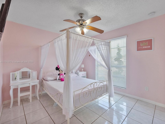 bedroom featuring tile patterned flooring, ceiling fan, baseboards, and a textured ceiling