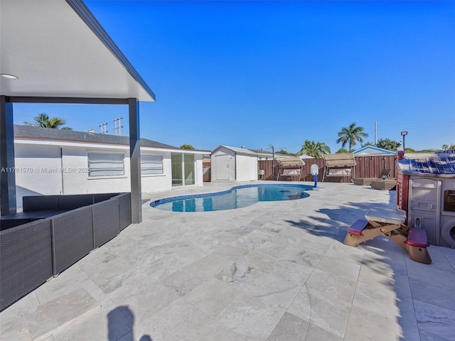 view of swimming pool with a fenced in pool, fence, a shed, an outdoor structure, and a patio