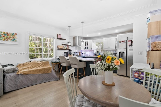 dining room with recessed lighting, light wood-type flooring, and ornamental molding