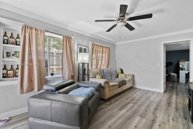 living room featuring baseboards, wood finished floors, a ceiling fan, and ornamental molding