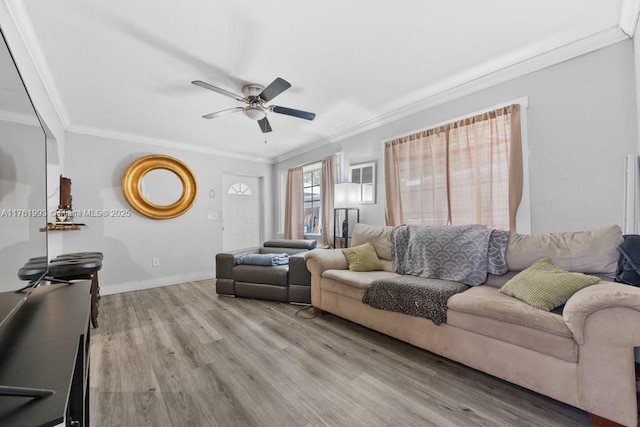 living area featuring ceiling fan, crown molding, light wood-type flooring, and baseboards