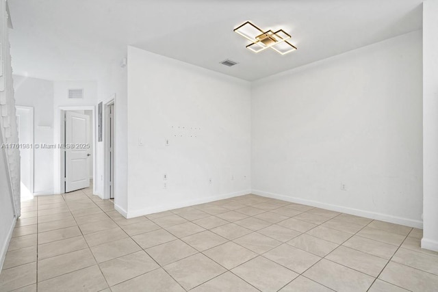 unfurnished room with baseboards and visible vents