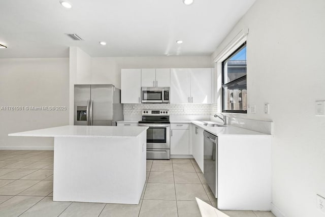 kitchen with tasteful backsplash, visible vents, a center island, stainless steel appliances, and a sink