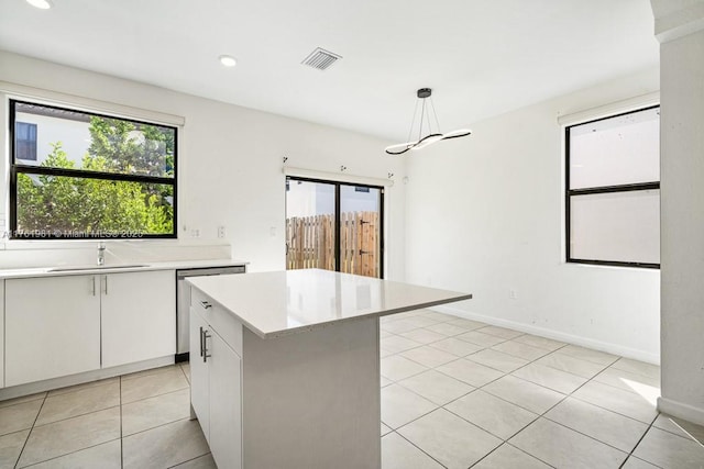 kitchen featuring light tile patterned floors, visible vents, a sink, light countertops, and stainless steel dishwasher