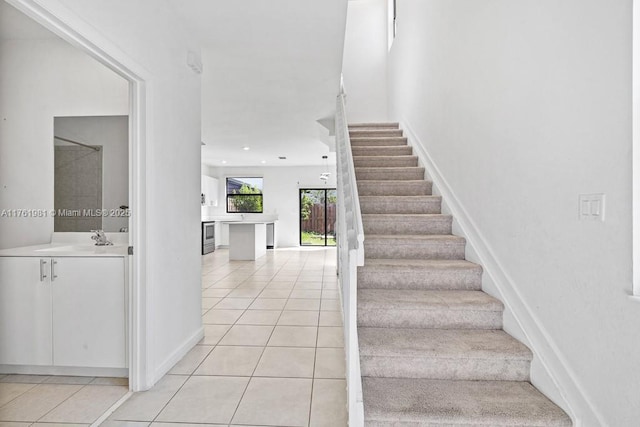 stairs with tile patterned floors and recessed lighting