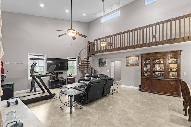 living area with recessed lighting, stairway, a towering ceiling, a ceiling fan, and baseboards