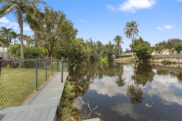 exterior space featuring a lawn, a water view, and fence