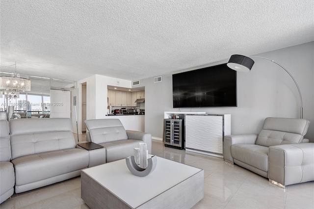 living room with an inviting chandelier, visible vents, and a textured ceiling