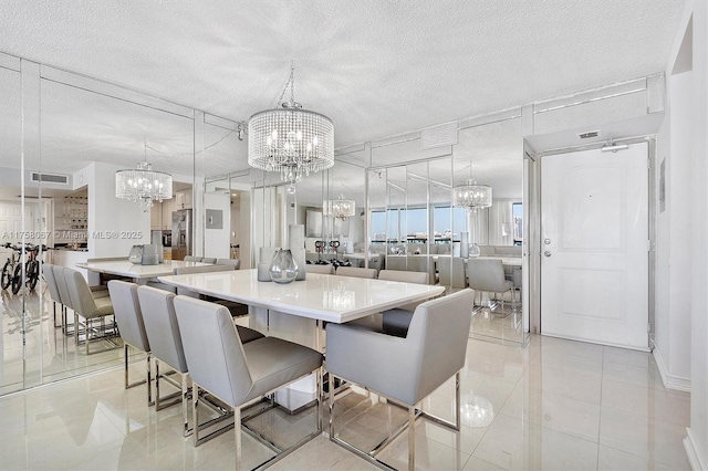 dining space with a notable chandelier, light tile patterned flooring, visible vents, and a textured ceiling