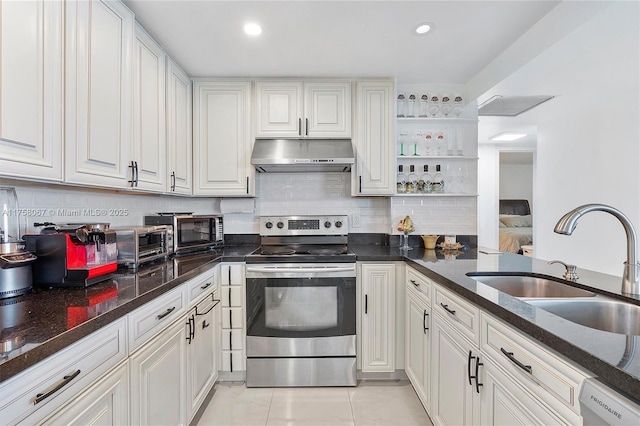 kitchen featuring under cabinet range hood, stainless steel electric stove, decorative backsplash, white cabinets, and a sink