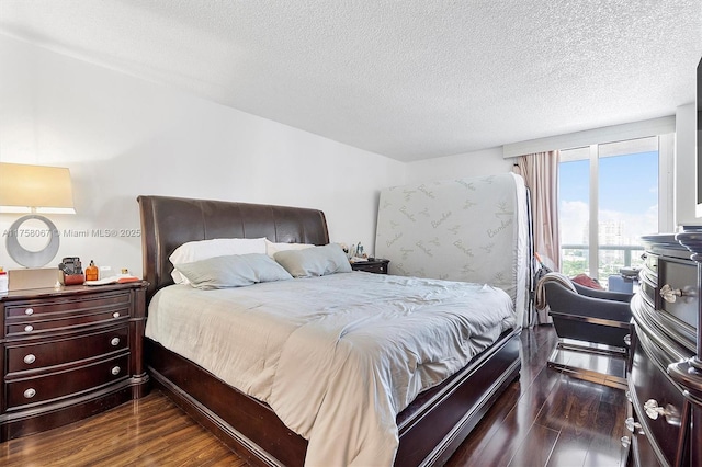 bedroom with a textured ceiling and dark wood finished floors