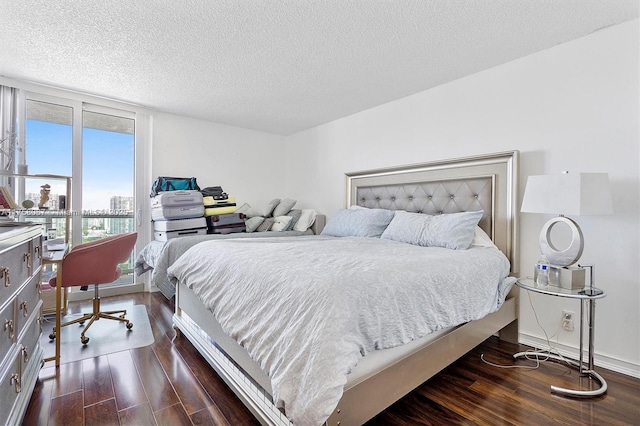 bedroom featuring a view of city, a textured ceiling, and dark wood finished floors