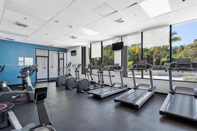 exercise room with a paneled ceiling and visible vents