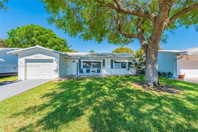 ranch-style home with a front yard, an attached garage, concrete driveway, and stucco siding