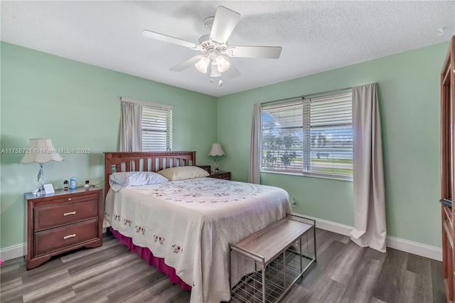 bedroom featuring a textured ceiling, a ceiling fan, baseboards, and wood finished floors