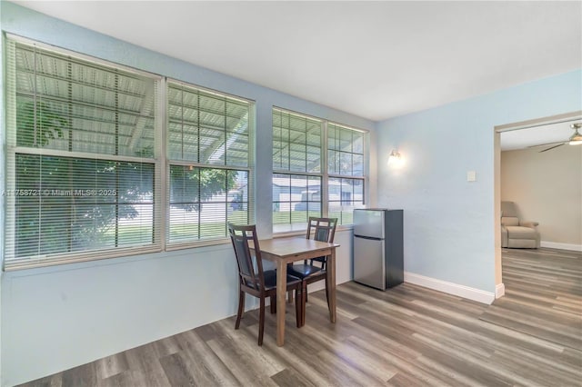 dining room with baseboards, wood finished floors, and a ceiling fan