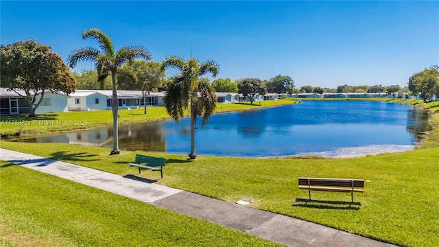 view of home's community featuring a lawn and a water view