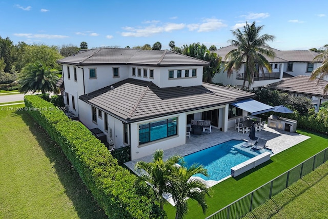 rear view of property with a yard, a fenced backyard, outdoor dry bar, and stucco siding