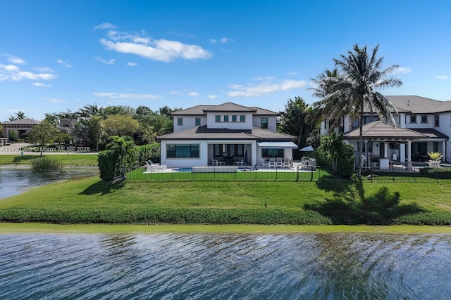 back of house featuring a patio, fence, a gazebo, a water view, and a lawn