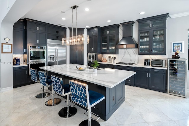 kitchen with light stone countertops, beverage cooler, a kitchen bar, appliances with stainless steel finishes, and custom exhaust hood