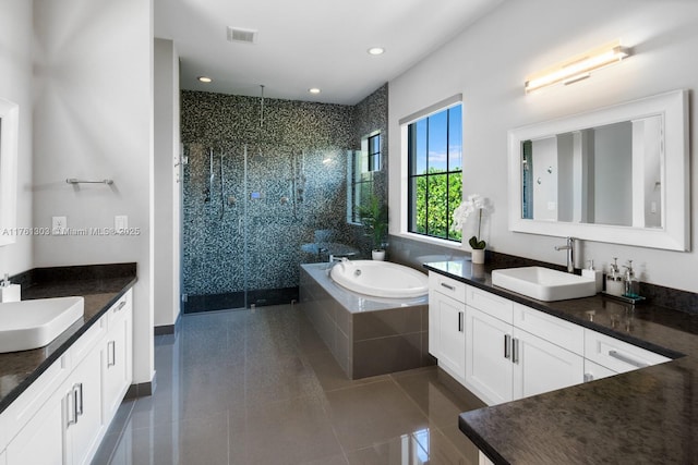 bathroom featuring a shower stall, two vanities, and a sink